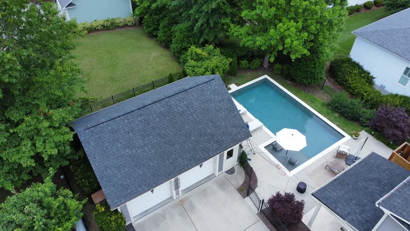 Aerial view of a detached garage roof beside a swimming pool